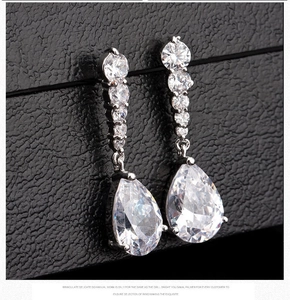 Macro shot of silver tassel earrings featuring sparkling zircon water drop pendants