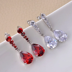 Macro shot of silver drop earrings with pear-cut red and clear cubic zirconia stones