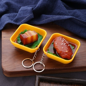Detailed view of realistic fake food keychains featuring braised pork and chicken wings