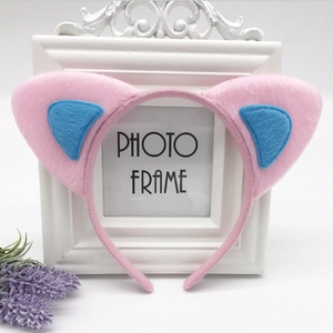 Close-up of pink and blue plush cat ear headband on a vintage white frame background