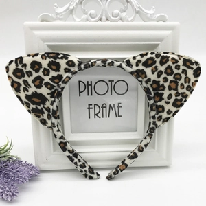 Detail of plush leopard print cat ears headband on a white decorative photo frame