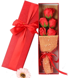 Close-up of artificial red soap roses bouquet in an open rectangular gift box with ribbon
