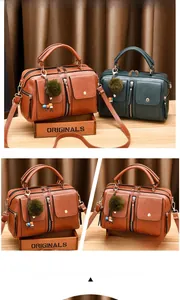 Close-up of vintage PU leather satchel bags with fur pompom charms in brown and green