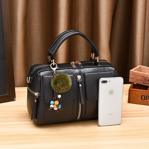 Fashionable black PU leather pillow handbag with gold hardware and green fur ball accessory
