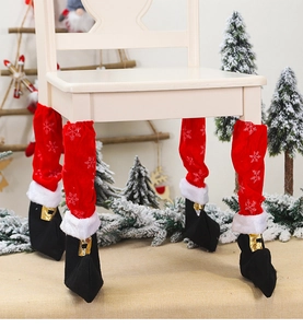 Detailed view of red Christmas elf shoe chair leg covers with white snowflakes and gold buckle