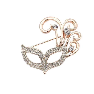 Macro detail of rose gold masquerade mask brooch with sparkling rhinestones and crystal accents