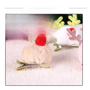 Dettaglio di fermagli natalizi con pompon di peluche e corna di renna glitterate su clip