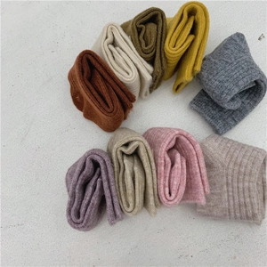 Assorted colors of thick wool socks in curly stack on a clean white background
