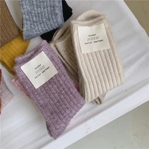 Detailed knit texture of thick wool socks in multiple colors with brand labels