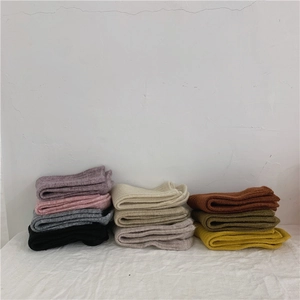 Stack of colorful thick wool socks in multiple colors including pink and green