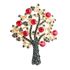 Close-up of golden Christmas tree brooch with sparkling red and green rhinestones