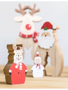 Close-up of wooden reindeer and snowman tabletop ornaments with festive painted details