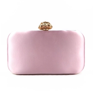 Close-up of lilac satin evening clutch bag with golden floral rhinestone clasp detail