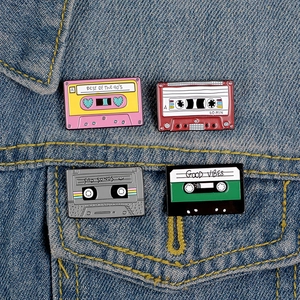 Set of four retro cassette enamel pins on denim jacket showing 90s vintage style