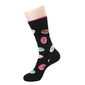 Détail d'une chaussette noire en coton avec motifs donuts colorés sur un support pied