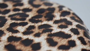 Macro shot of high-quality leopard print texture on leather fabric for fashion accessories