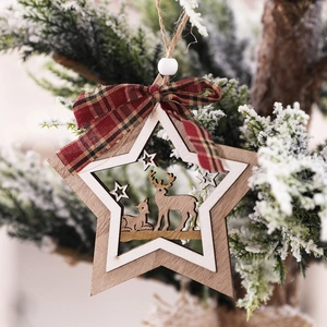 Star-shaped wooden Christmas ornament with reindeer cutout on a snow-covered pine tree