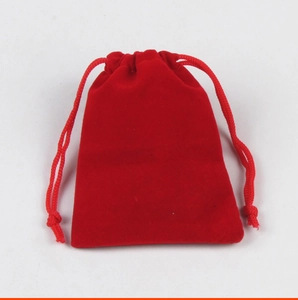 Dettaglio del sacchetto in velluto rosso con coulisse, consistenza morbida e cuciture