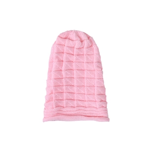 Close-up of pink knitted beanie showing soft checkered texture and folded cuff detail