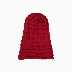 Detailed view of red knitted beanie with thick mesh texture and folded cuff style