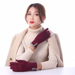 Detail of wine red winter glove featuring grey faux fur trim and three decorative buttons
