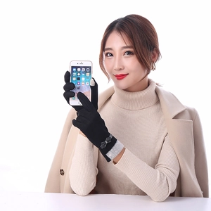 Detail showing woman wearing black thermal touch screen gloves with grey faux fur trim