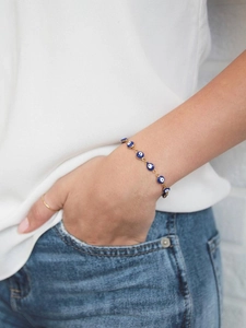 Detailed view of Turkish Evil Eye bracelet with blue beads on a female wrist