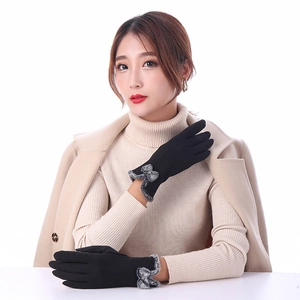 Detail of warm winter gloves for women with soft plush trim and gray bow ornament