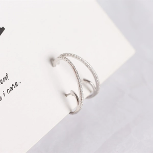 Macro shot of silver S925 sterling silver double-row C-shaped hoop earrings with crystals