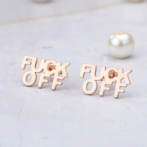 Rose gold FUCK OFF letter stud earrings on a textured marble surface for women