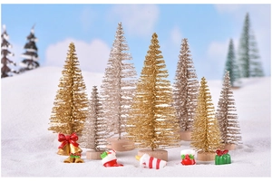 Miniature gold and champagne Christmas trees with frosted snow on a festive landscape