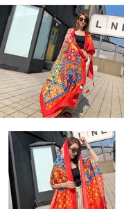 Detail of bohemian floral print scarf with vibrant multi-color silk texture finish