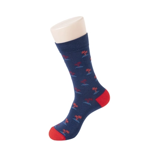 Detail of navy crew socks with coconut tree patterns and red toe heel accents