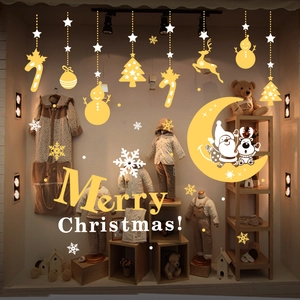 Close-up of gold Christmas window clings featuring reindeer, stars and Merry Christmas text