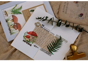 Flat lay of vintage botanical PET stickers with mushroom and fern designs on linen fabric