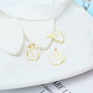 Close-up of creative rock gesture enamel pins set pinned on a white canvas bag