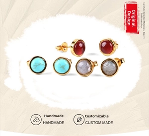 Detailed view of three pairs of round gemstone stud earrings in red, blue, and gray colors