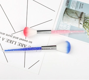 Close-up of pink and blue tapered makeup brushes with crystal diamond glitter handles