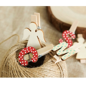 Détail de pinces de Noël en bois avec anges et lettres sur une cordelette en jute