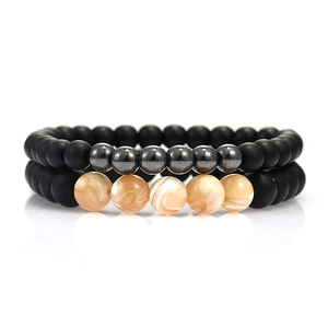 Close-up of matte black beads with tiger eye and marble stones on handmade bracelets