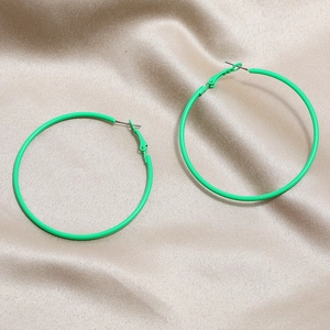 Neon green retro hoop earrings on silk fabric for a stylish 80s vintage look
