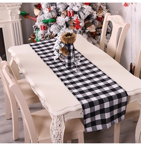 Close-up of black and white buffalo plaid table runner and matching wine bottle cover