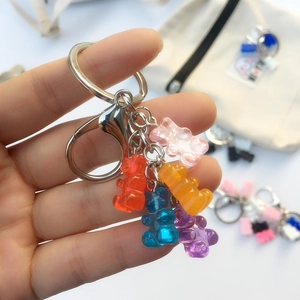 Macro detail of five colorful resin gummy bears on a silver metal keychain hook