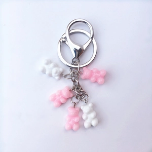 Close-up of pink and white resin bear charms with silver metal ring and lobster clasp