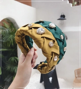 Detail of dark green and yellow braided headbands with sparkling rhinestones and silk texture