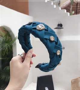 Detailed view of handmade woven wide headband in dark green with five sparkling rhinestones