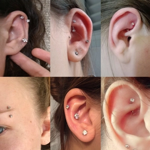 Detailed view of stainless steel curved barbell piercing with cubic zirconia on ear and lip