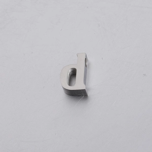 Macro view of a silver brushed stainless steel letter 'd' bead with a small hole