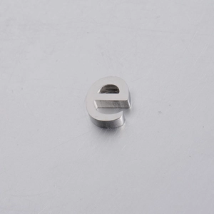 Macro shot of 10mm silver brushed stainless steel letter E charm bead for jewelry making