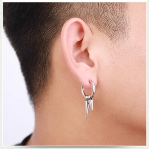Punk style stainless steel hoop earrings with double cone spikes worn by a man